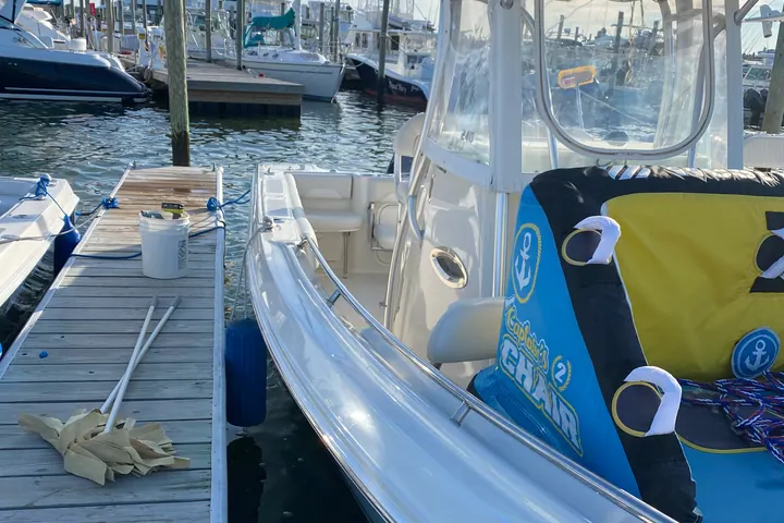 A detailed center console tied alongside a timber dock at a Long Island marina, boats and slips stretching out behind