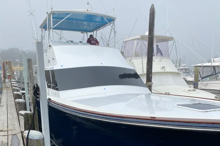 Center console and sport boats lined up in their slips at a North Fork marina under a clear sky