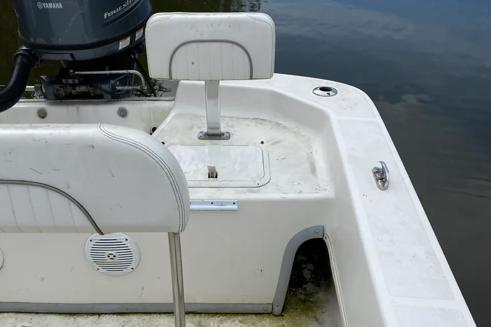 The cockpit of a white centre console before detailing, its non-skid deck stained dark with mildew, algae and ground-in dirt