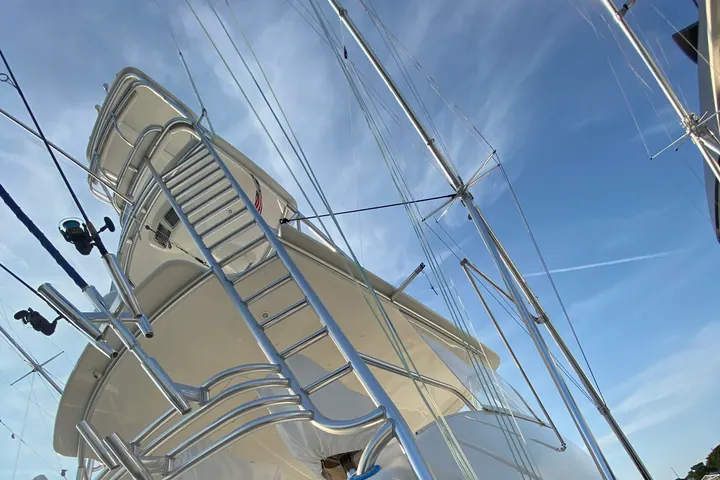 Late sun flaring off the polished white flybridge and outriggers of a convertible sport fisherman