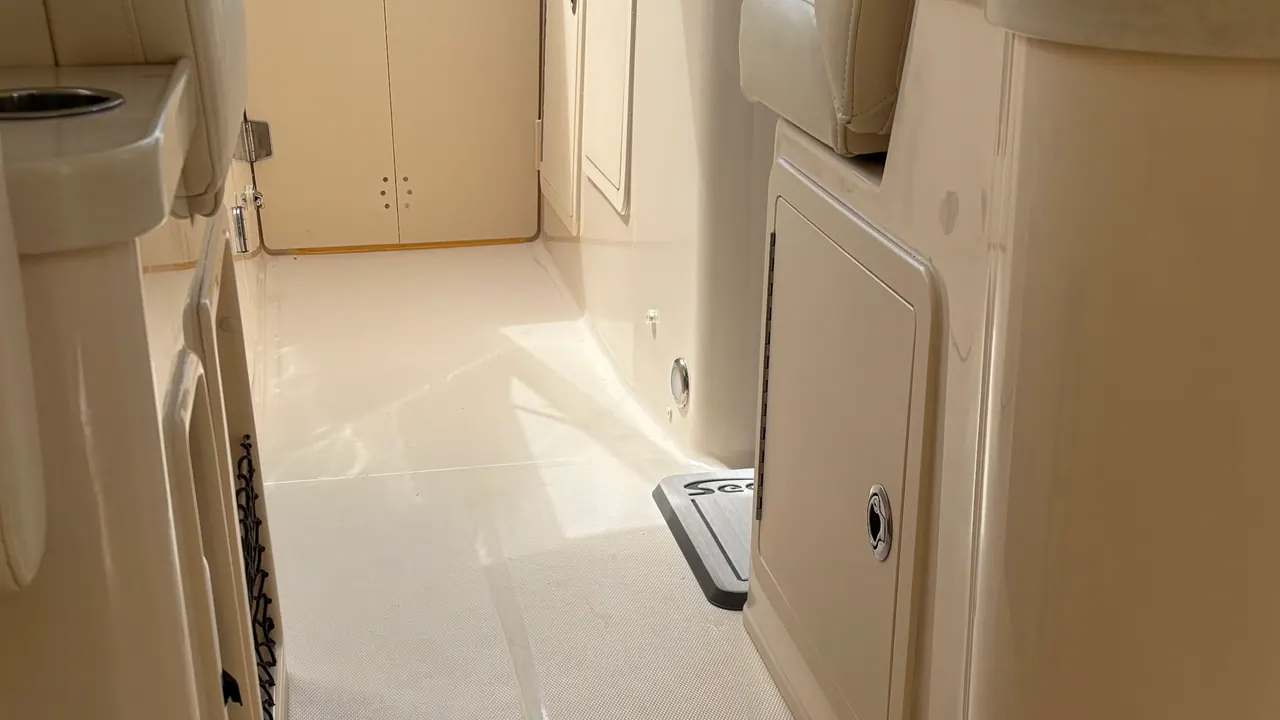 The cream vinyl upholstery and wet bar of a cruiser's cockpit after an interior detail, sponge and cleaner still sitting on the sink